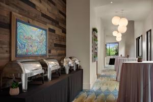 um restaurante com mesas e um quadro na parede em SpringHill Suites by Marriott San Diego Oceanside/Downtown em Oceanside