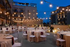 a wedding reception with white tables and chairs and lights at SpringHill Suites by Marriott San Diego Oceanside/Downtown in Oceanside