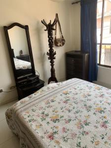 a bedroom with a bed with a dresser and a mirror at Casa Merce in Pereira