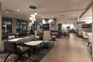 a lobby with tables and chairs and a salon at Residence Inn Minneapolis Maple Grove/Arbor Lakes in Maple Grove
