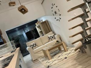 salon z białą kanapą i schodami w obiekcie La Salamandre de l Olivier - Le Magnolia w mieście Aubignosc