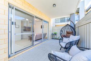 een patio met stoelen en een hangmat op een balkon bij Swan Valley Serviced Apartments in Middle Swan