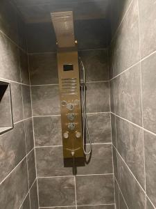 La salle de bains est pourvue d'une douche avec un panneau de contrôle. dans l'établissement La Salamandre de l Olivier - Le Magnolia, à Aubignosc