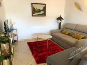 sala de estar con sofá y alfombra roja en Chez Laurenn, en Le Carbet