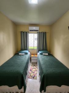 2 łóżka w małym pokoju z oknem w obiekcie Apartamento w mieście Florianópolis