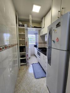 kuchnia z lodówką i podłogą wyłożoną kafelkami w obiekcie Apartamento w mieście Florianópolis