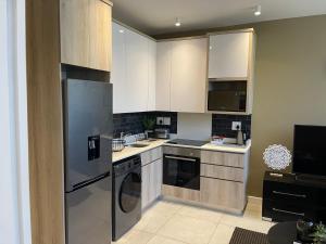 a kitchen with stainless steel appliances and white cabinets at Zimbali Boulevard Suite 210 in Ballito