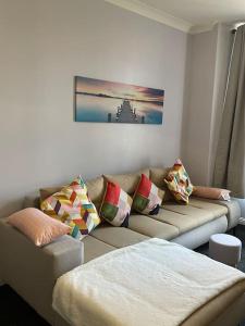 uma sala de estar com um sofá com almofadas em Spacious one bedroom flat, entire property. em Greenock