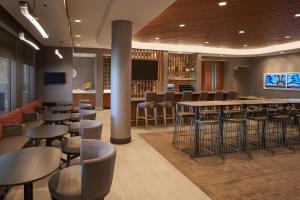 a bar with stools and tables in a restaurant at SpringHill Suites by Marriott Fort Myers Estero in Estero