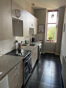 a kitchen with a sink and a stove top oven at Spacious one bedroom flat, entire property. in Greenock