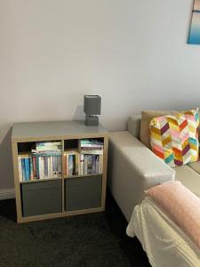 a room with a couch and a book shelf with books at Spacious one bedroom flat, entire property. in Greenock