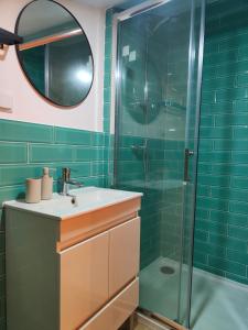 a bathroom with a sink and a glass shower at Wood Essence Apartment - Cozy Balcony in Coimbra