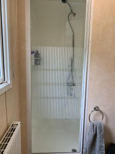 a shower with a glass door in a bathroom at Sunrise 132 in Lincolnshire