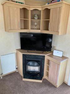 a entertainment center with a television and a fireplace at Sunrise 132 in Lincolnshire