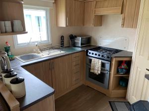 a small kitchen with a stove and a sink at Sunrise 132 in Winthorpe