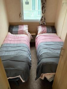 two beds in a small room with a window at Sunrise 132 in Lincolnshire
