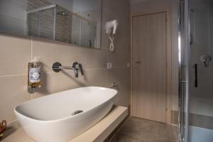 ein Badezimmer mit einer großen weißen Badewanne und einer Dusche in der Unterkunft Hotel La Tavola Rotonda in Assisi