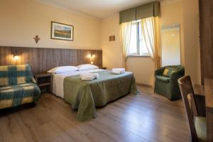 een hotelkamer met een bed en twee stoelen bij Hotel La Tavola Rotonda in Assisi