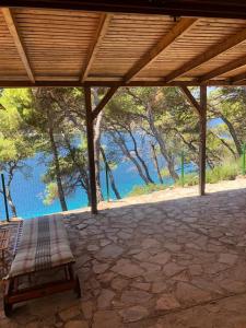 a porch with a bench under a wooden roof at Apartment by the sea Žirje with private heated hydromassage pool in Žirje