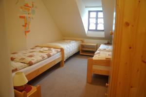 um pequeno quarto com 2 camas e uma janela em Penzion Po Vode em Cesky Krumlov