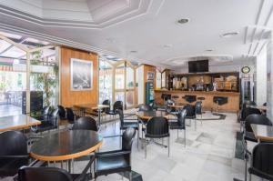 a restaurant with tables and chairs in a room at EL ESTUDIO DE LA PLAYA BENALBEACH 804 Holidays Paradise in Benalmádena