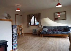 uma sala de estar com um sofá e uma mesa em The Singing Heart, TirNaNog Cozy Cottage near Lochgilphead !!HIDDEN GEM!! em Lochgilphead
