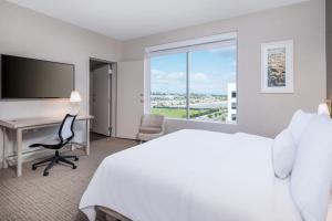 a hotel room with a bed and a desk and a window at Element San Jose Airport in San Jose