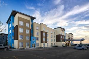 a row of buildings in a parking lot with a car at TownePlace Suites by Marriott Edmonton Sherwood Park in Sherwood Park