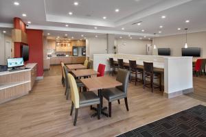 un restaurante con mesas y sillas y una cocina en TownePlace Suites by Marriott Edmonton Sherwood Park, en Sherwood Park