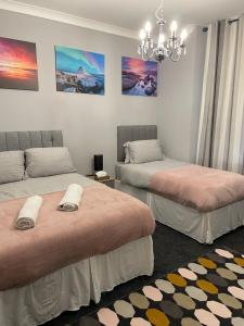 a room with two beds and a chandelier at Spacious one bedroom flat, entire property. in Greenock