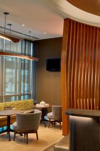 a dining room with tables and chairs and a curtain at SpringHill Suites by Marriott Atlanta Airport Gateway in Atlanta