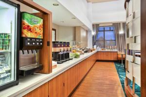 a fast food restaurant with a counter with food at SpringHill Suites by Marriott Chicago Southwest at Burr Ridge Hinsdale in Burr Ridge