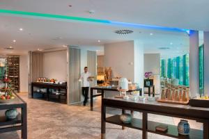 a man is standing in a room with a buffet at Delta Hotels by Marriott Frankfurt Offenbach in Offenbach