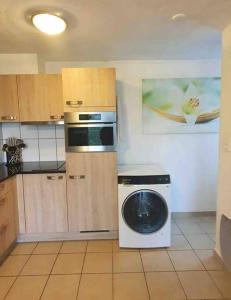 een keuken met een fornuis en een wasmachine bij Superbe appartement 3.5 avec cheminée in Gruyères