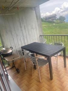 einen Tisch und Stühle auf einer Veranda mit Grill in der Unterkunft Superbe appartement 3.5 avec cheminée in Gruyères
