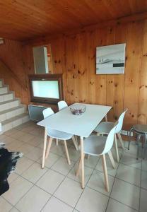 een eetkamer met een witte tafel en stoelen bij Superbe appartement 3.5 avec cheminée in Gruyères