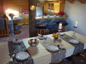 een keuken met een tafel met borden en kaarsen erop bij Chalet des Laix in La Rosière
