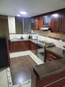 a kitchen with wooden cabinets and a stove top oven at Casa Grande con parqueadero in Ipiales