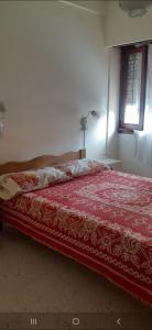 1 dormitorio con 1 cama con edredón rojo en Depto en Sab Ber en San Bernardo