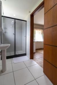 a bathroom with a glass shower and a sink at Kings International Hotel in Rio das Flores