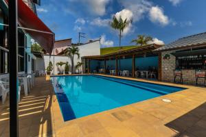a swimming pool in front of a house at Kings Boutique Hotel in Rio das Flores