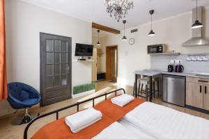 a bedroom with a large bed and a blue chair at Anova Apartman in Gyula