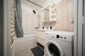 La salle de bains est pourvue d'un lave-linge et d'un lavabo. dans l'établissement Appartement climatisé terrasse parking 8 couchages, à Marseille