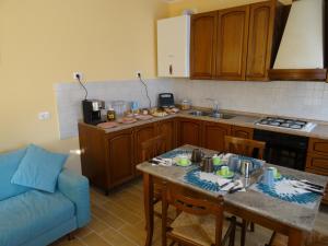 a kitchen with a table and a blue couch at B&B Giardino di Ro in Cazzago di Pianiga