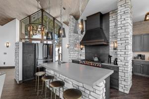 une cuisine avec un mur de briques et un comptoir avec des tabourets dans l'établissement Skyes Peak - Beautiful NEW home with breathtaking views of the Mountains, à Estes Park