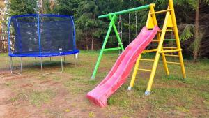 a playground with a slide and two chairs at Beautiful Villa For Family/Couples in Molėtai