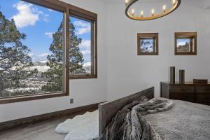 une chambre avec un lit et de grandes fenêtres dans l'établissement Skyes Peak - Beautiful NEW home with breathtaking views of the Mountains, à Estes Park