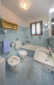 a blue tiled bathroom with a toilet and a sink at B&B IL GERLO in Casargo