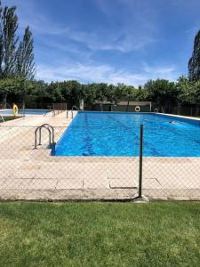 a large swimming pool with a fence around it at Guadarrama, ático nuevo con espectaculares vistas in Guadarrama