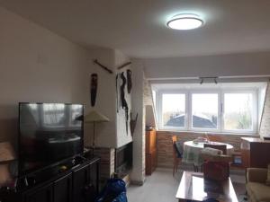 a living room with a large television and a table at Guadarrama, ático nuevo con espectaculares vistas in Guadarrama
